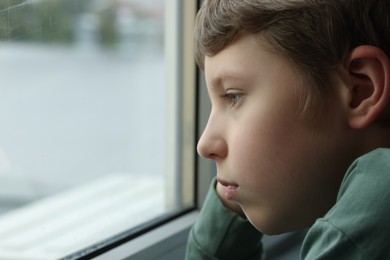 Photo of Autism concept. Lonely little boy near window at home, space for text