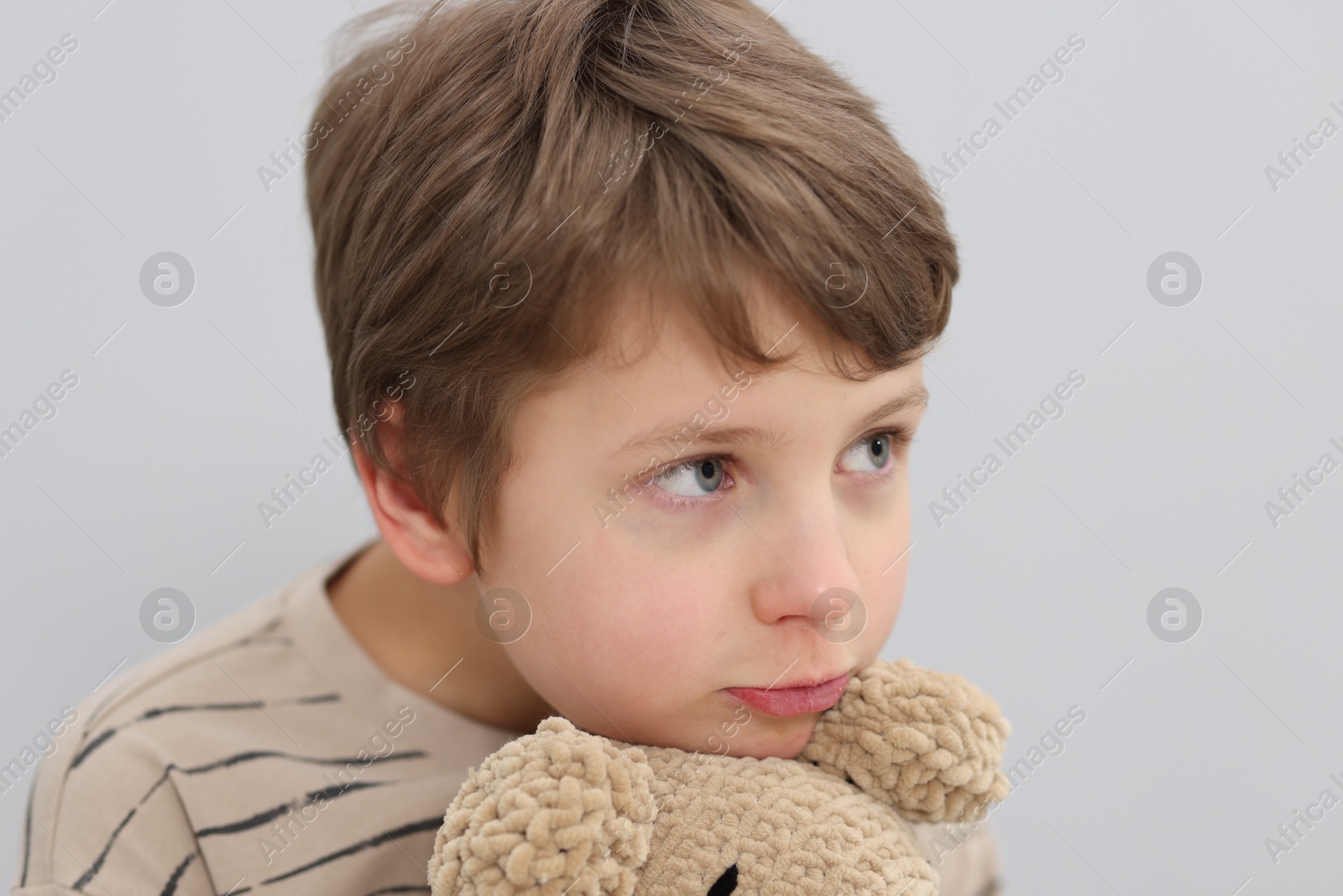 Photo of Autism concept. Lonely little boy with toy on grey background