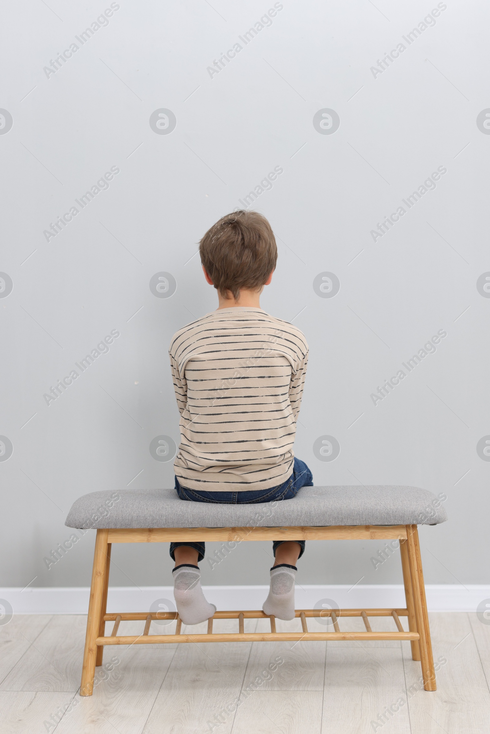 Photo of Autism concept. Lonely little boy on bench at home, back view