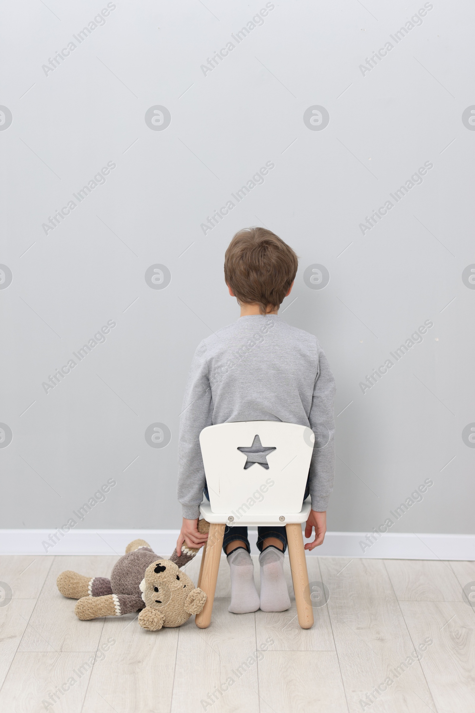 Photo of Autism concept. Lonely little boy with teddy bear at home