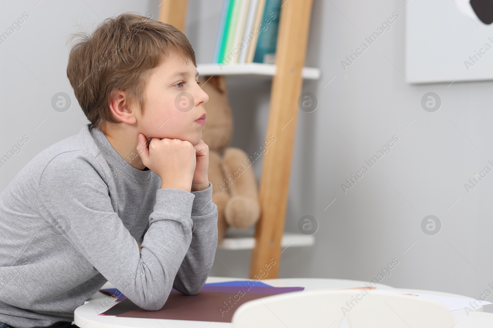 Photo of Autism concept. Lonely little boy at table indoors, space for text