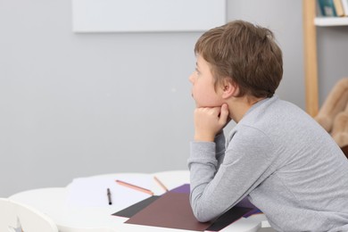 Photo of Autism concept. Lonely little boy at table indoors, space for text