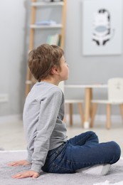 Autism concept. Lonely little boy on floor at home