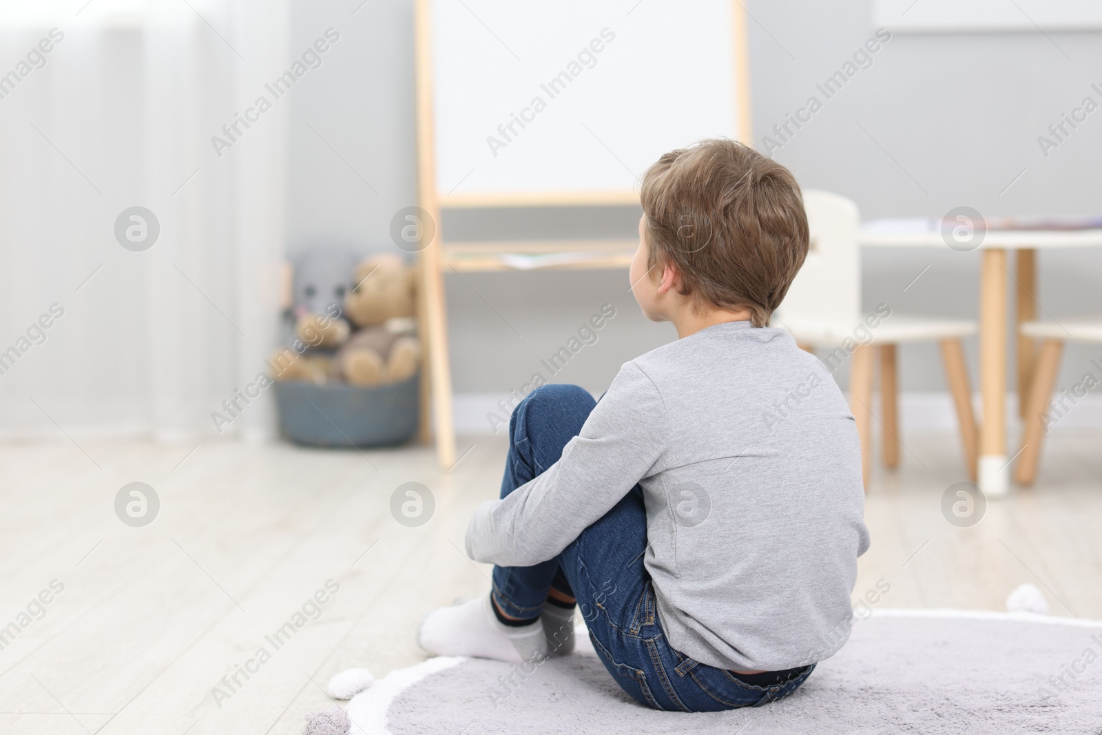 Photo of Autism concept. Lonely little boy on floor at home, space for text