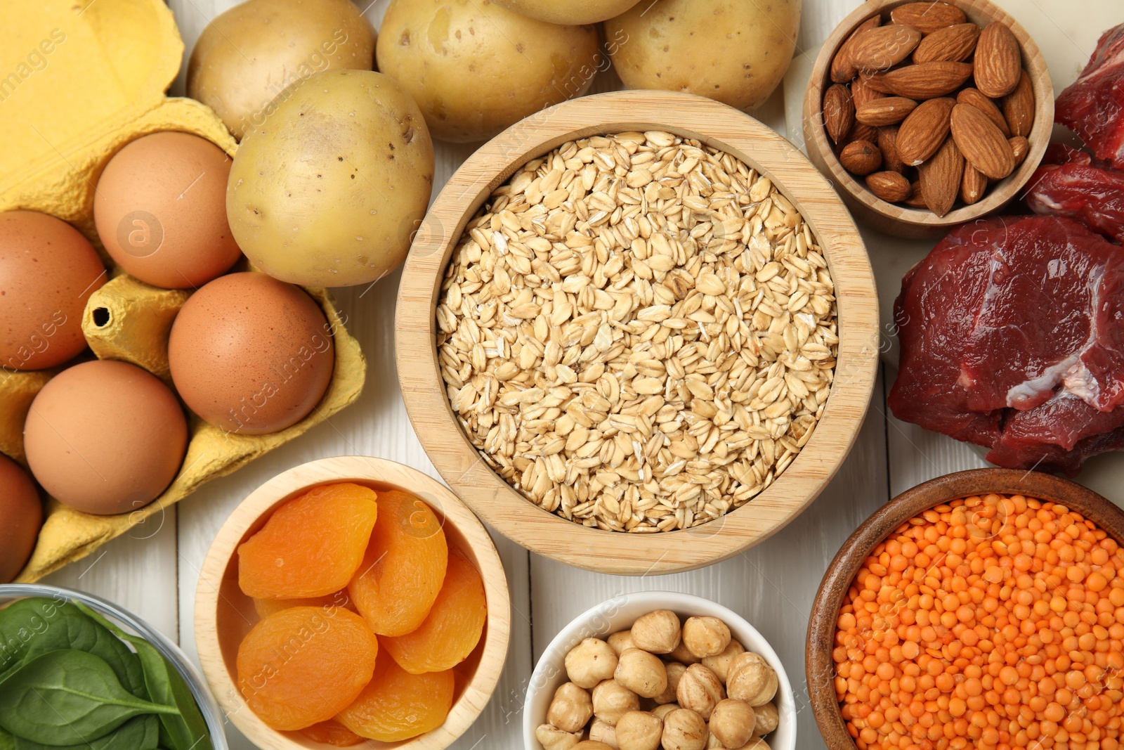 Photo of Different products rich in iron on white wooden table, flat lay. Diet plan for anemia