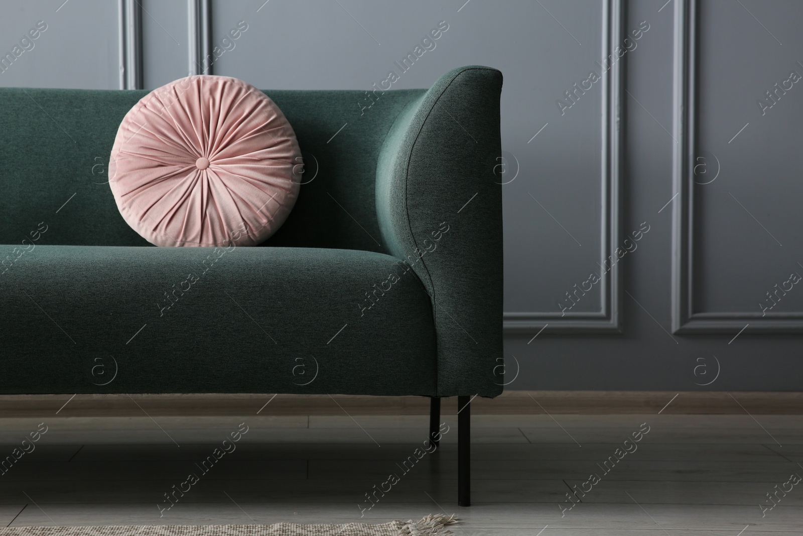 Photo of Stylish sofa with cushion near grey wall