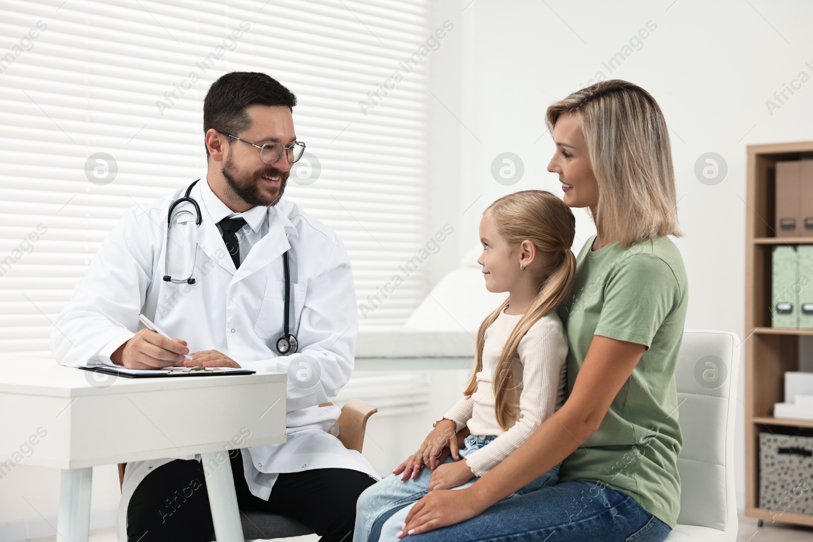 Photo of Doctor consulting little girl and her mother in hospital