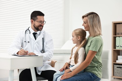 Doctor consulting little girl and her mother in hospital