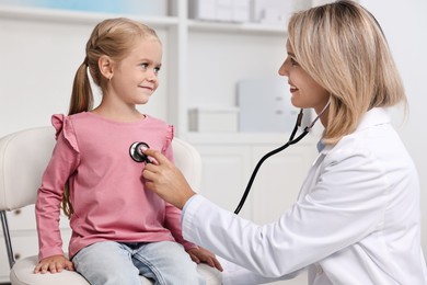 Photo of Doctor examining little girl with stethoscope in hospital