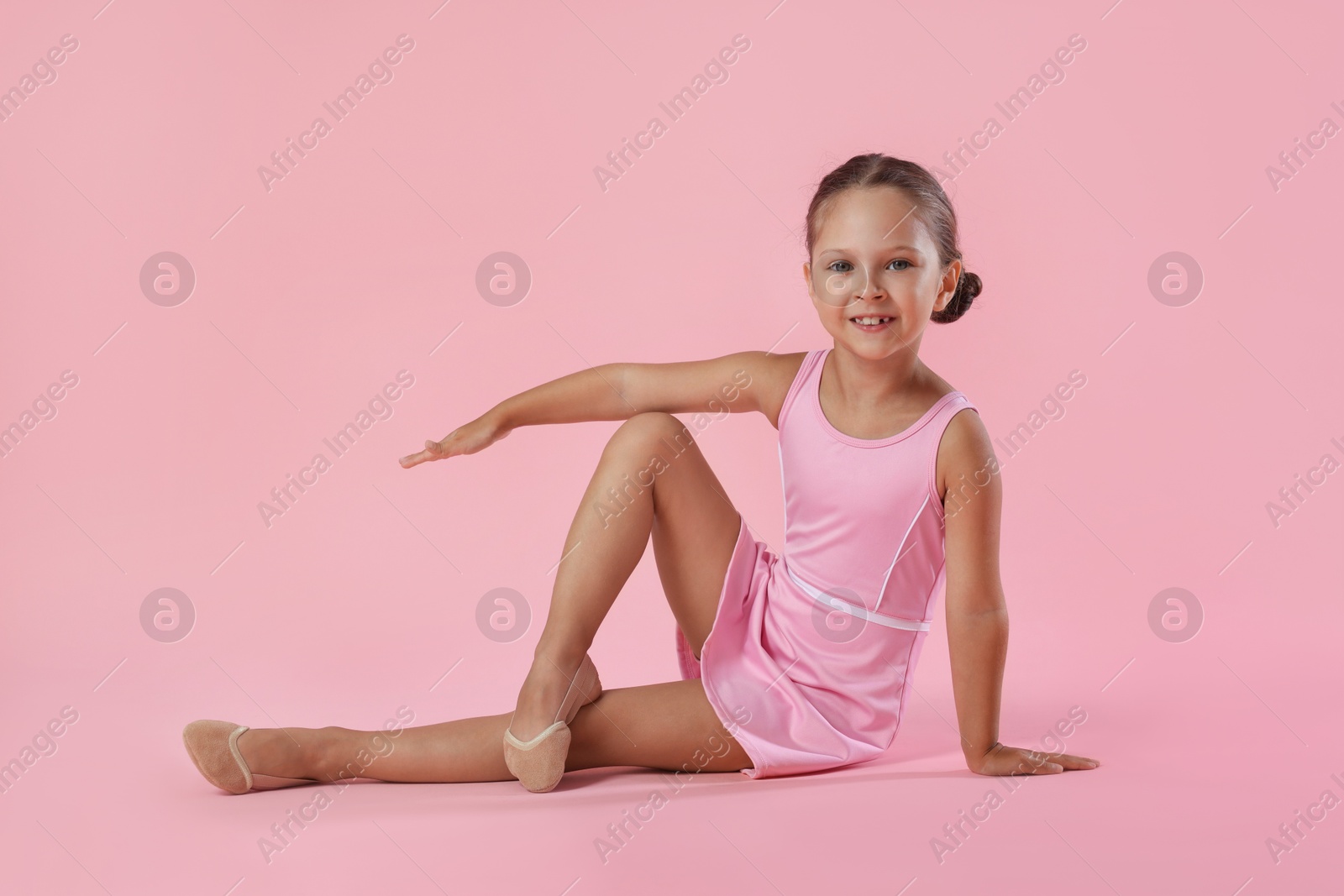 Photo of Portrait of little ballerina on pink background