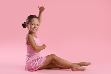 Photo of Portrait of little ballerina on pink background