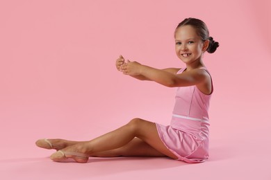 Photo of Portrait of little ballerina on pink background