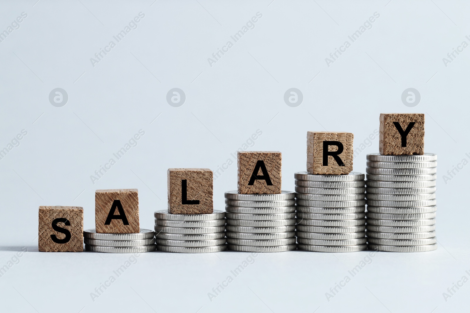 Photo of Word Salary made of wooden cubes and coins on light grey background, space for text