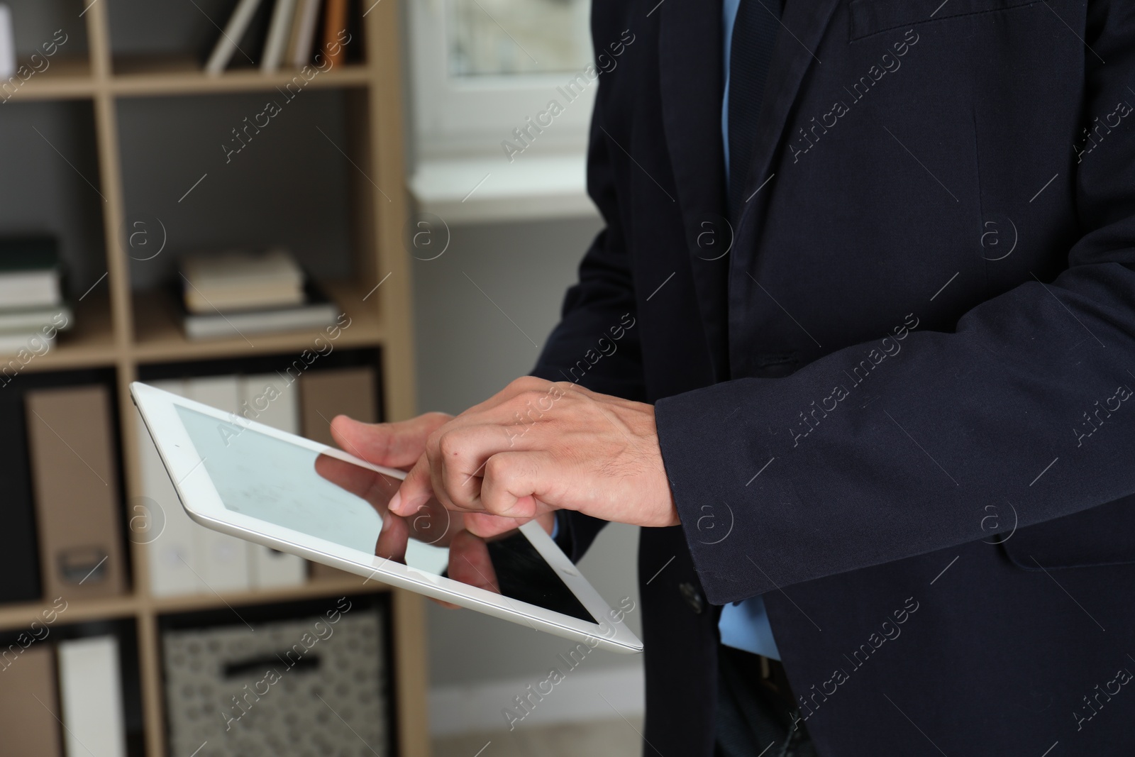 Photo of Businessman using tablet in office, closeup. Modern technology