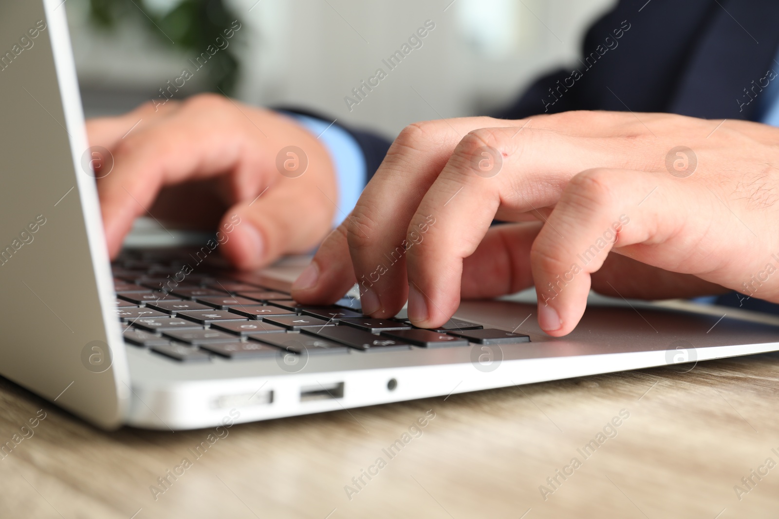 Photo of Businessman using laptop at table, closeup. Modern technology