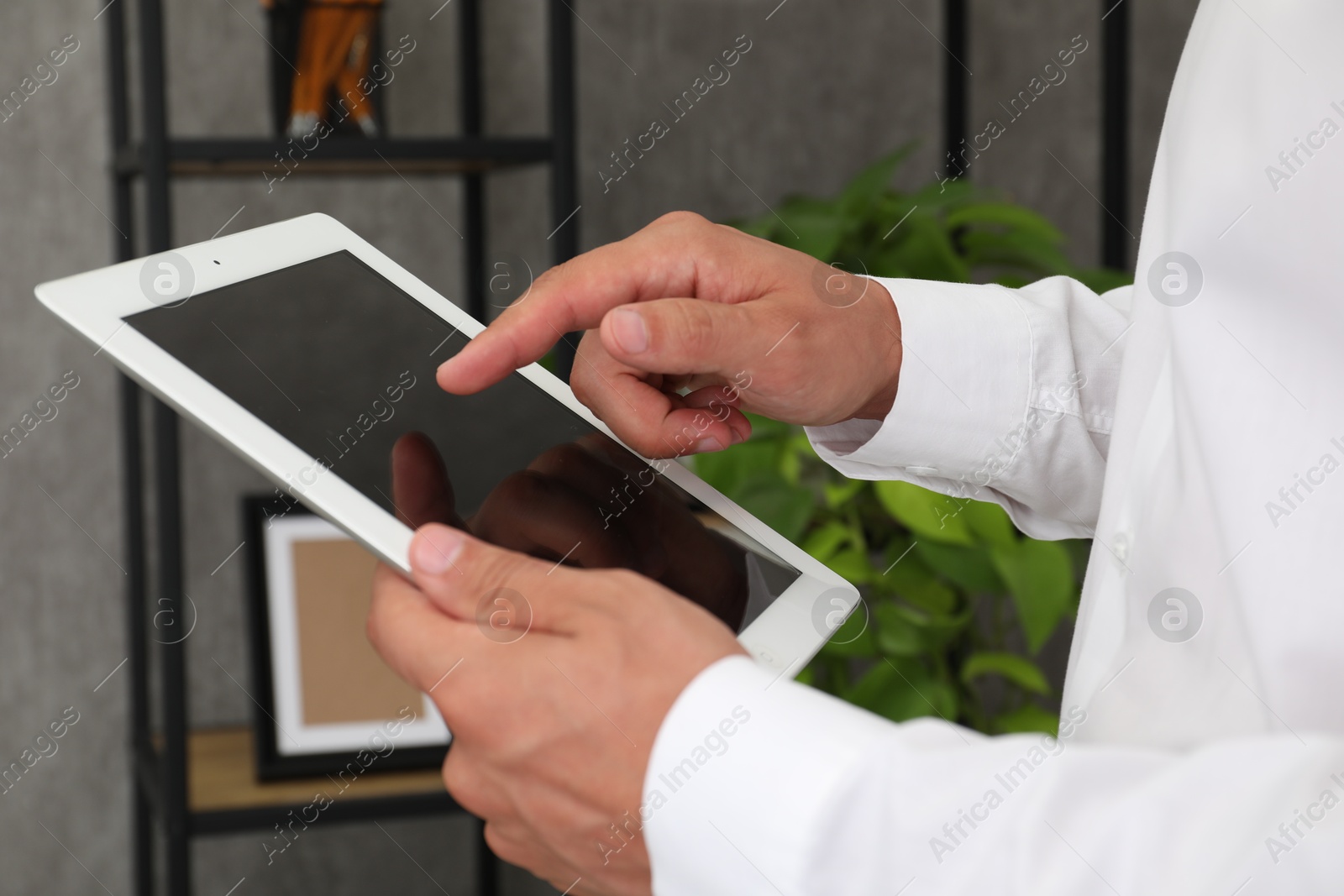 Photo of Businessman using tablet in office, closeup. Modern technology