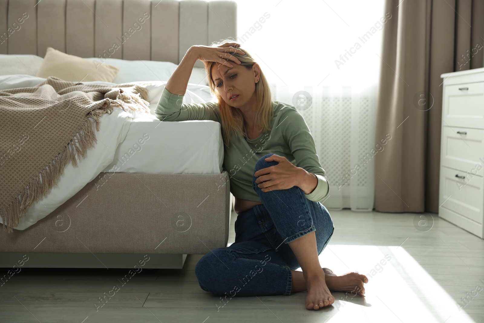 Photo of Menopause. Woman suffering from hot flash on floor at home