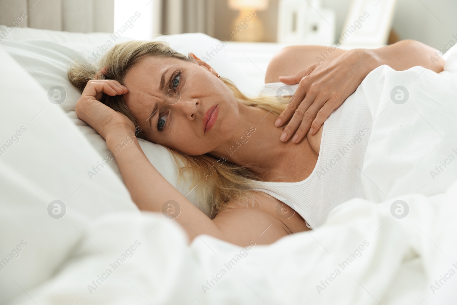 Photo of Menopause, sleep problems. Woman suffering from insomnia in bed indoors