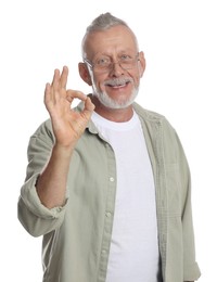 Photo of Portrait of smiling senior man showing ok gesture on white background