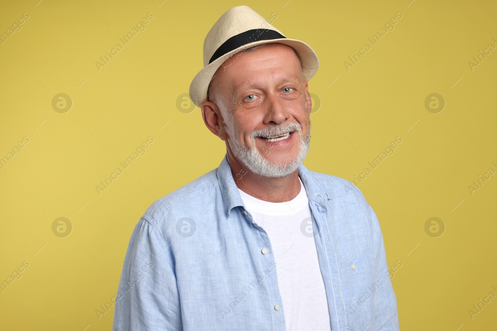 Photo of Portrait of happy senior man on yellow background