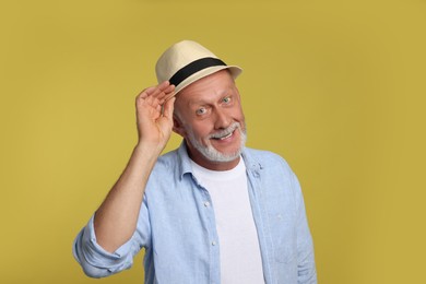 Portrait of happy senior man on yellow background