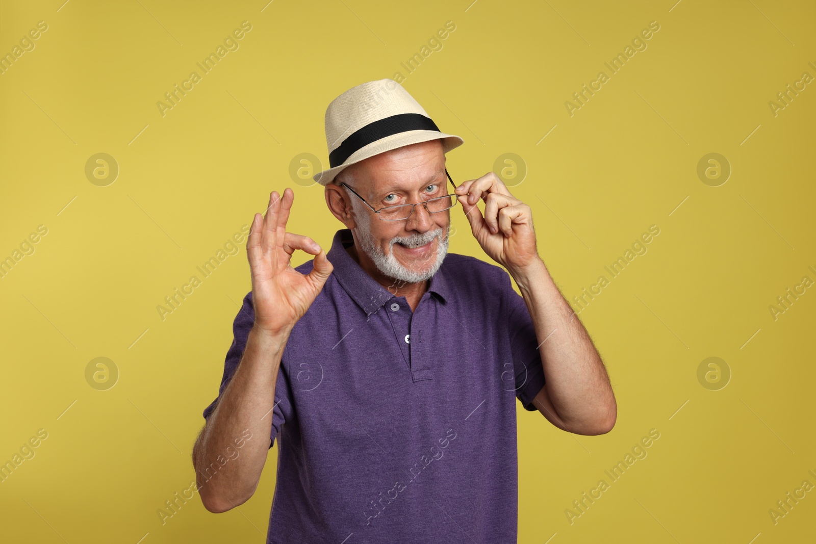 Photo of Portrait of handsome senior man showing ok gesture on yellow background