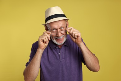 Portrait of handsome senior man on yellow background