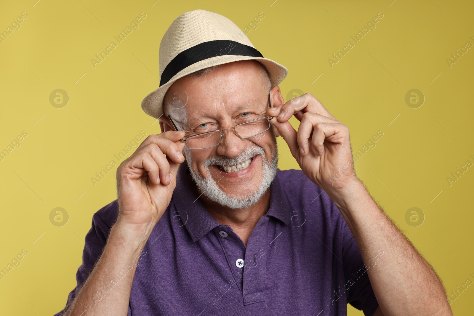 Photo of Portrait of happy senior man on yellow background