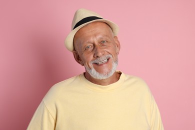 Portrait of happy senior man on pink background