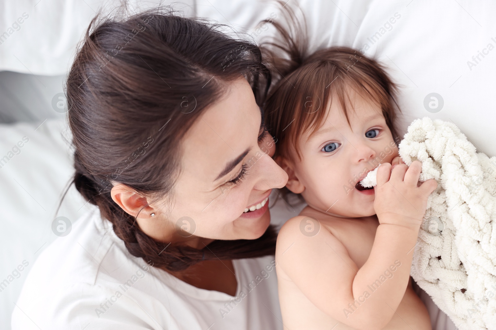 Photo of Beautiful young mother with her cute little baby on bed