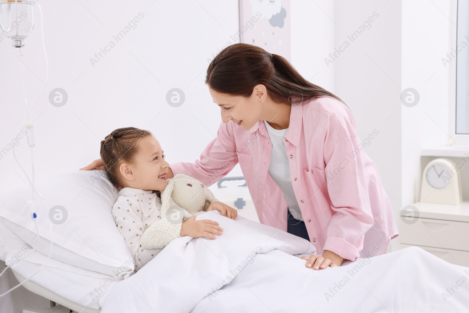 Photo of Mother and her little daughter on bed in hospital