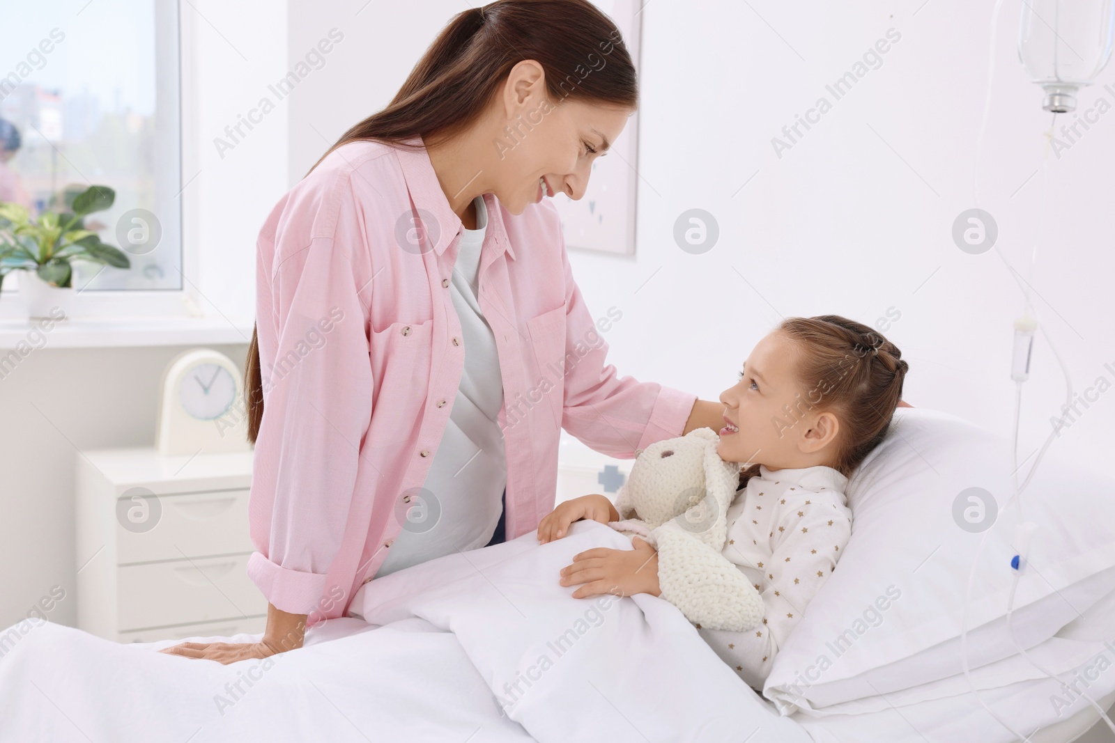 Photo of Mother and her little daughter on bed in hospital