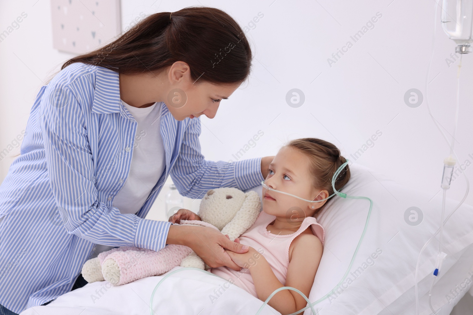 Photo of Mother and her little daughter on bed in hospital