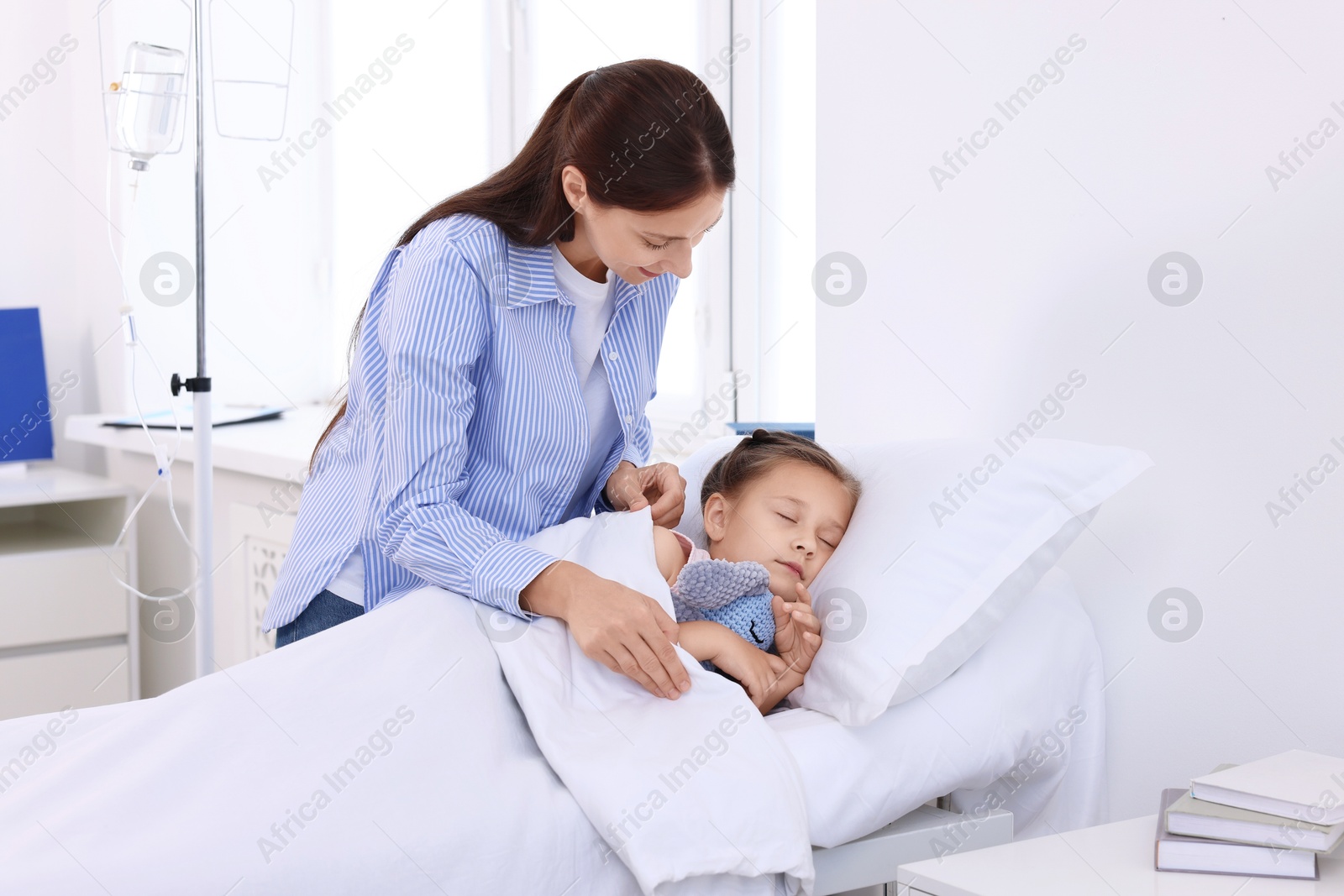 Photo of Mother and her little daughter on bed in hospital