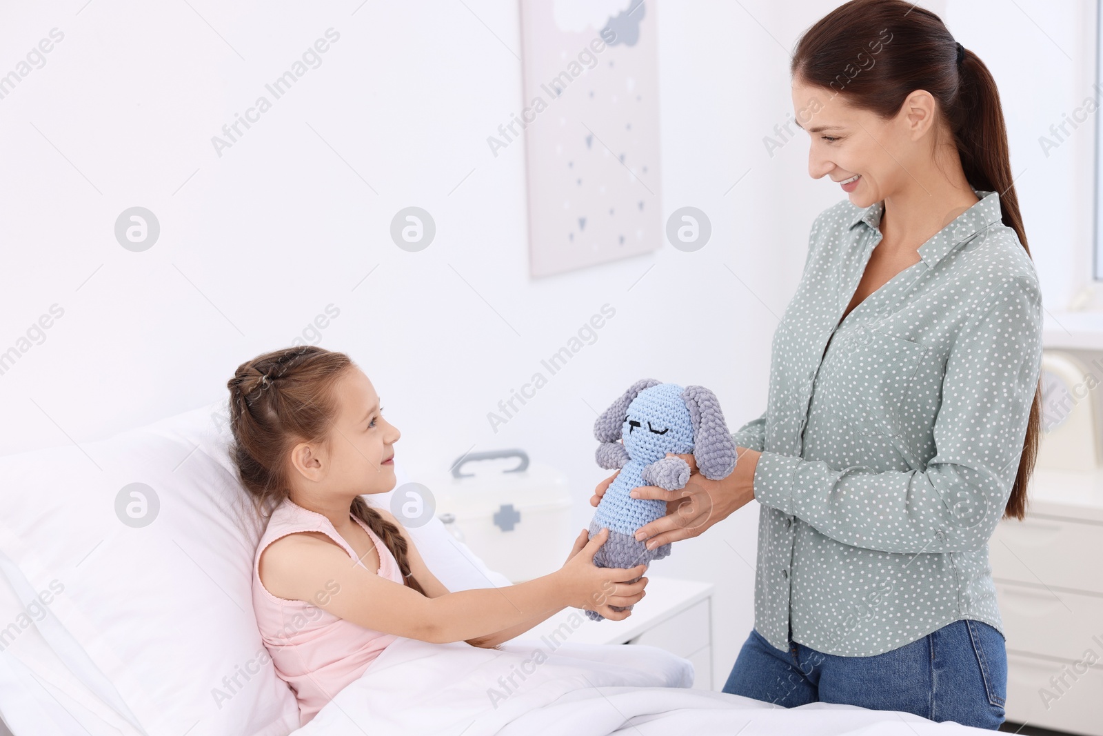 Photo of Mother and her little daughter on bed in hospital