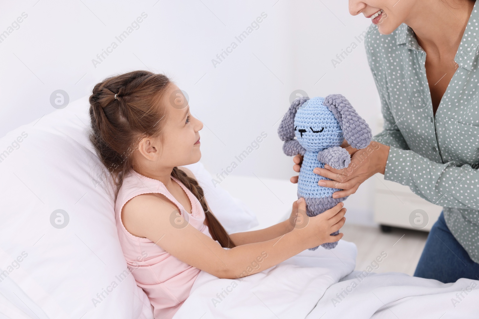 Photo of Mother and her little daughter on bed in hospital