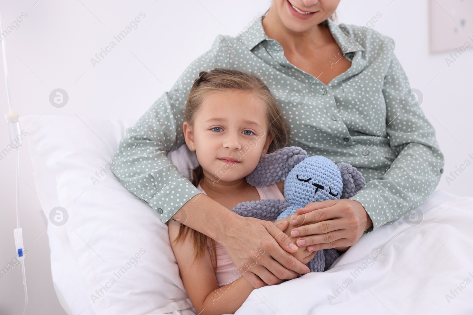 Photo of Mother and her little daughter on bed in hospital