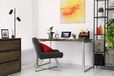 Fashion designer`s workplace with laptop and different supplies on table