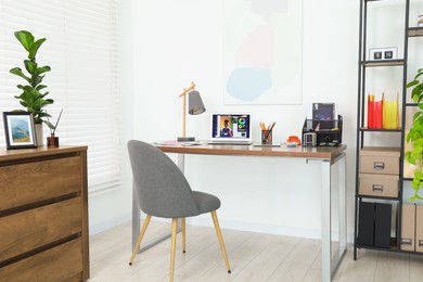 Photo of Fashion designer`s workplace with laptop and different supplies on table