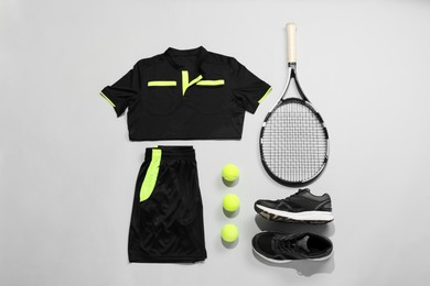 Photo of Tennis racket, balls and sportswear on light background, flat lay