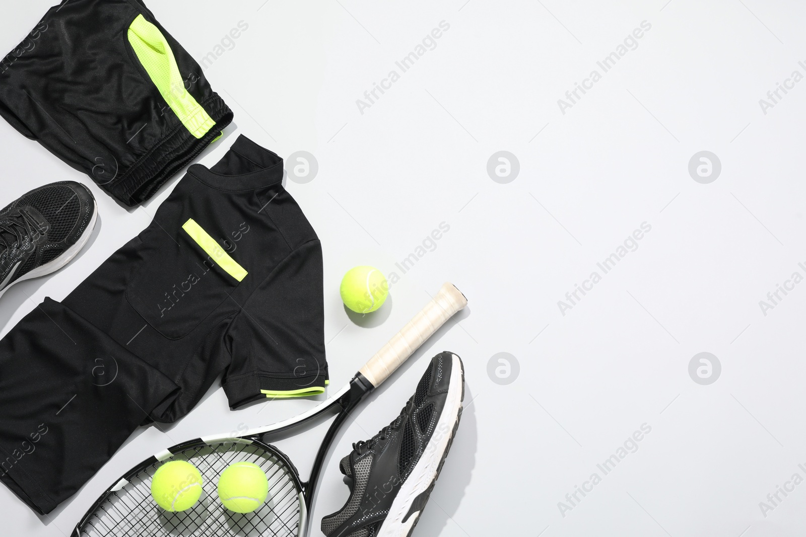 Photo of Tennis racket, balls and sportswear on light background, flat lay. Space for text