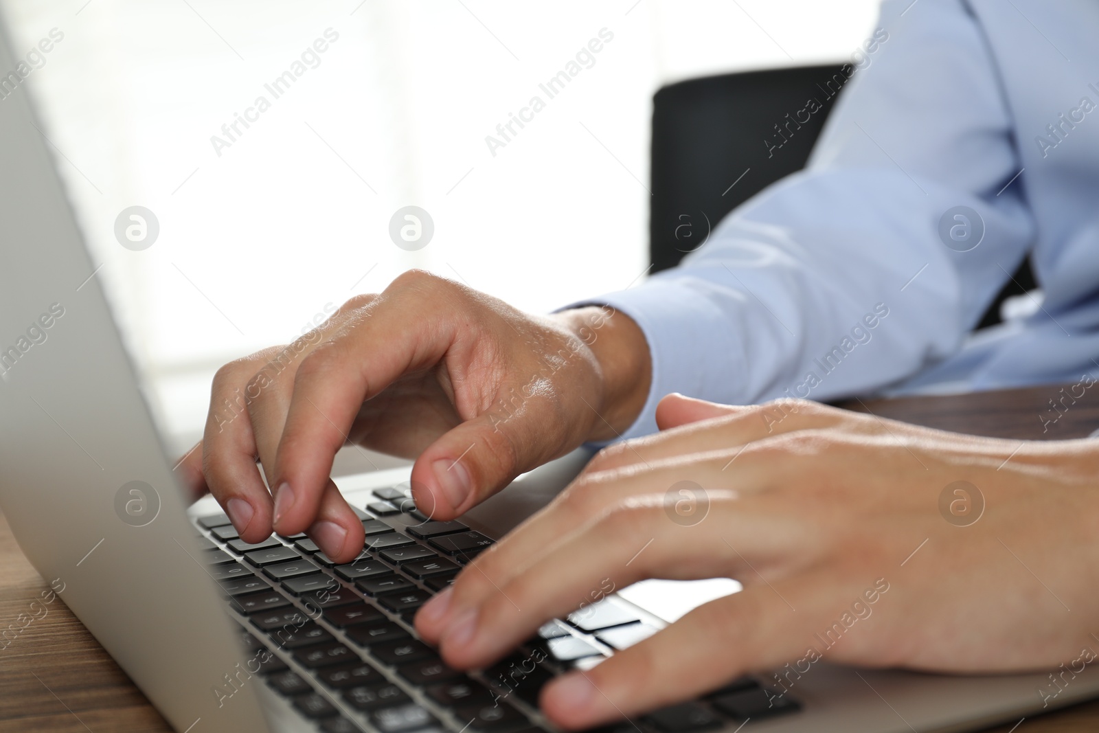 Photo of Businessman using laptop at table, closeup. Modern technology