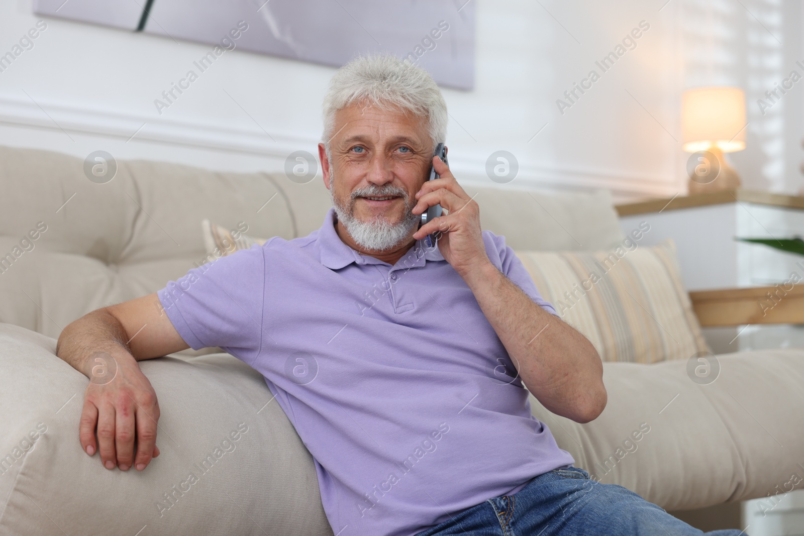 Photo of Senior man talking on phone at home