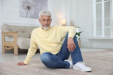 Photo of Senior man sitting on floor at home