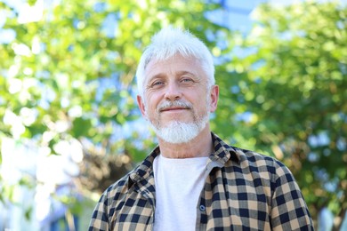 Photo of Portrait of senior man outdoors, low angle view