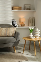 Photo of Sofa with soft cushion and coffee table in living room. Interior design