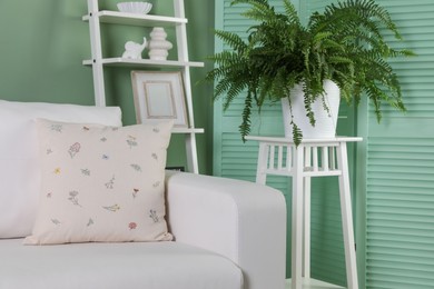 Photo of Beautiful living room interior with cozy sofa and houseplant near folding screen