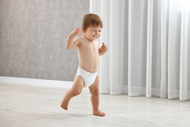 Photo of Cute little child in diaper at home