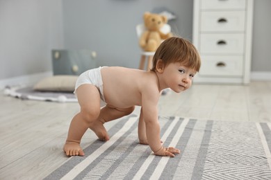 Photo of Cute little child in diaper at home