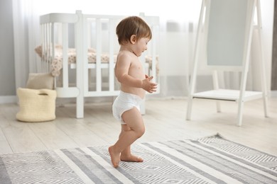 Photo of Cute little child in diaper at home